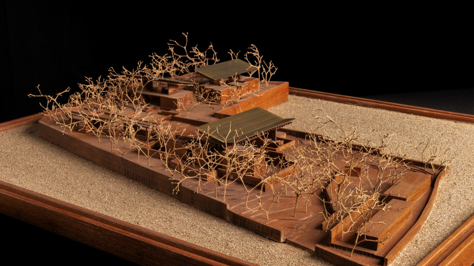 Study model of the commune on a sand base, linked pavilions set among wire trees