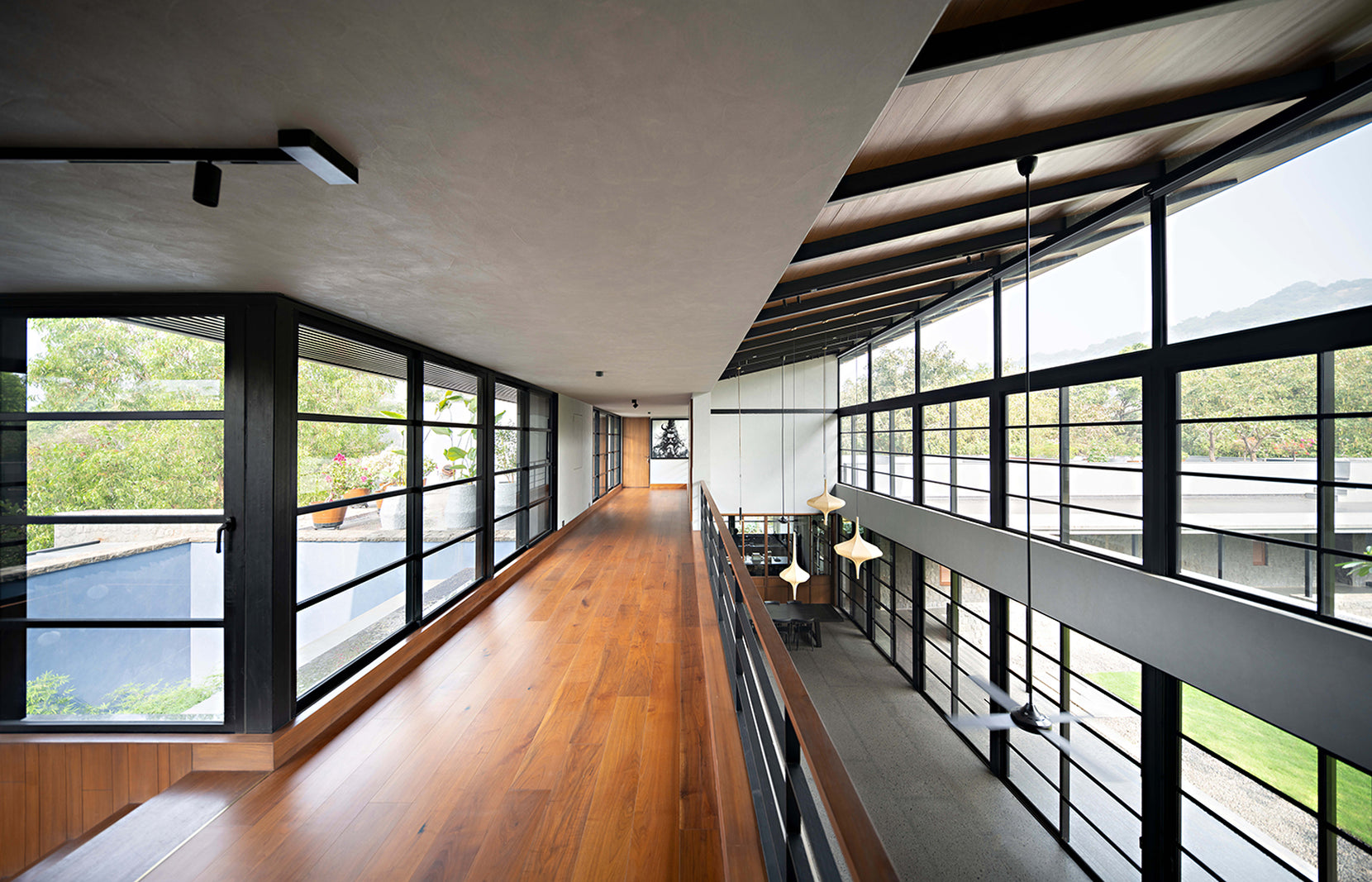 Upper-level timber gallery running between full-height windows above the double-height room