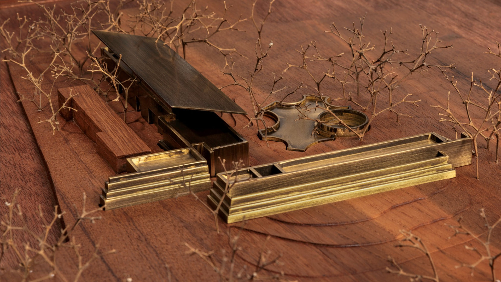 Scale model in brass and timber, the long wings of the house laid across a wooden base
