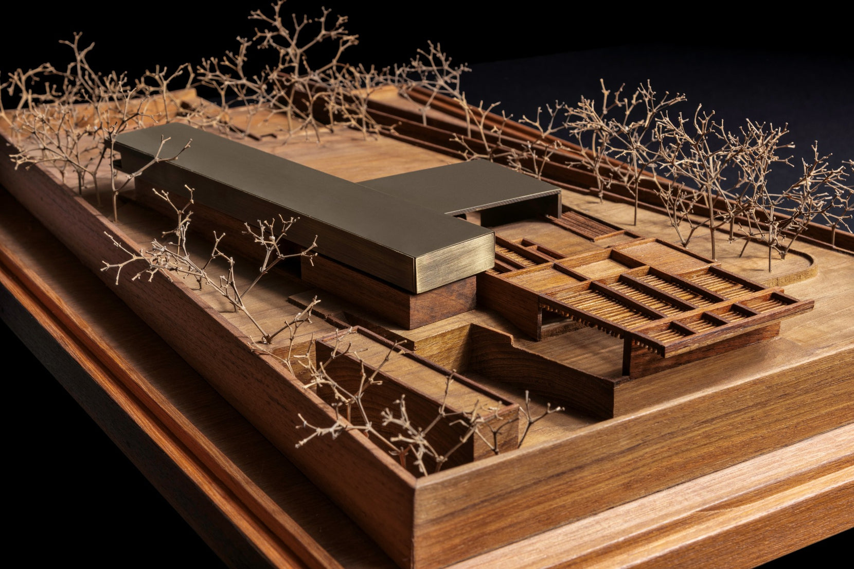 Study model in timber and brass, oblique showing the long roof and courtyard grid