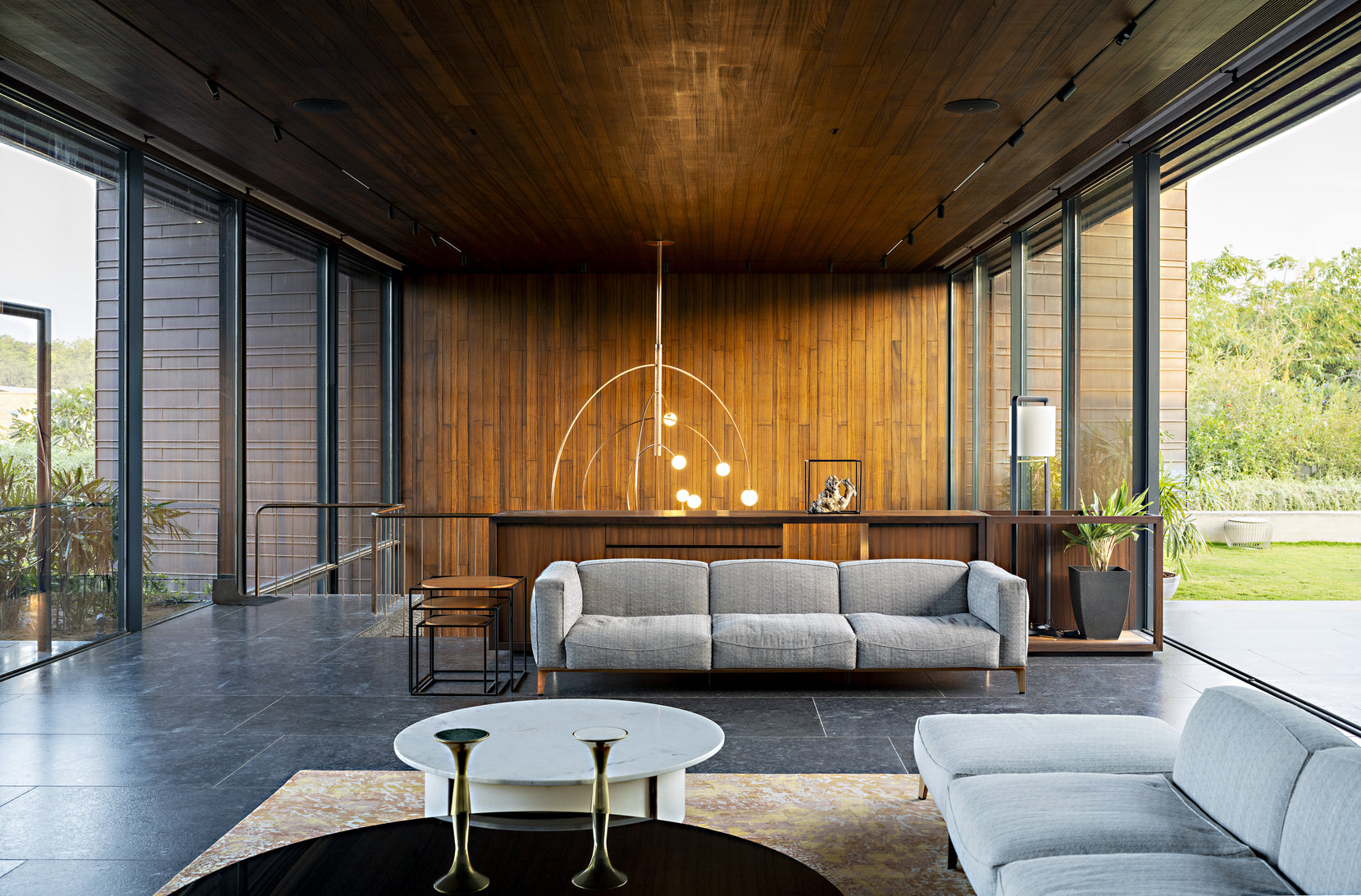 Sitting room panelled in teak, sliding glass on both sides opening to garden and court