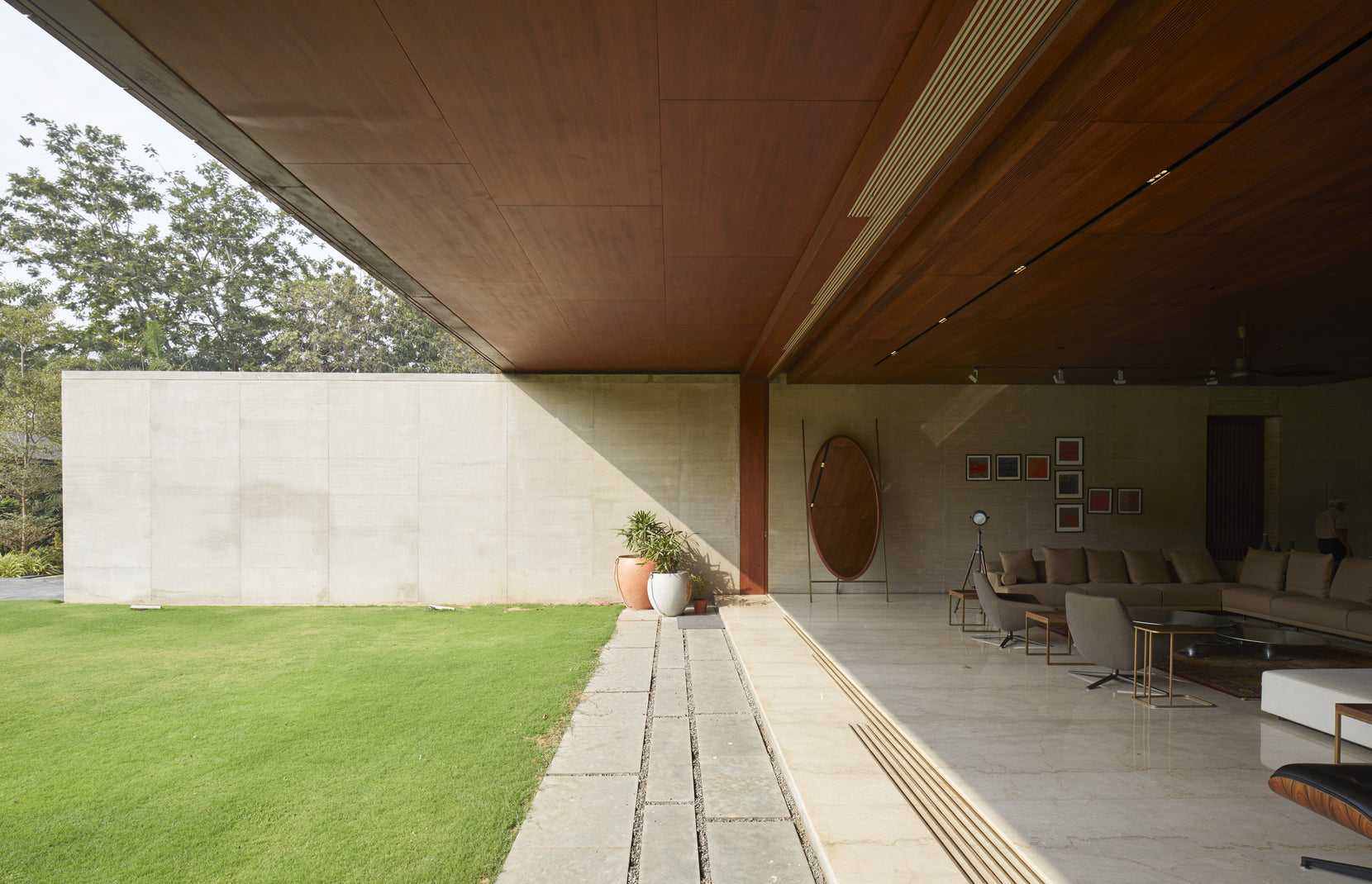 Column-free canopy reaching over the lawn beside the concrete wall of the sitting room