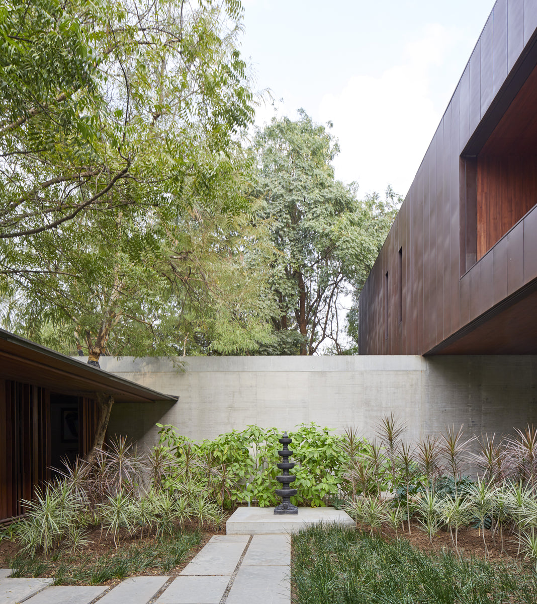 Planted courtyard between the concrete garden wall and the corten upper storey