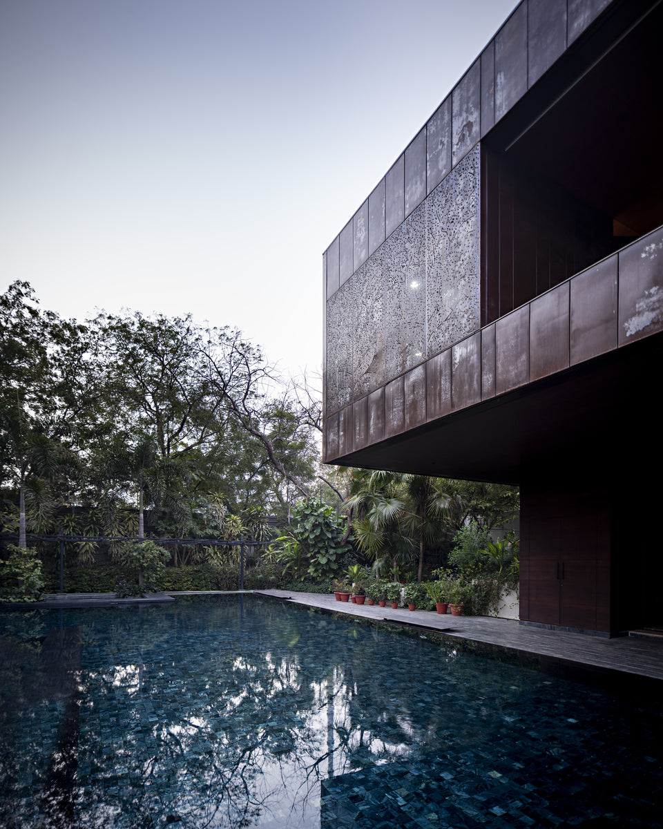 Diya House in Ahmedabad, its corten-clad upper floor cantilevered over the swimming pool