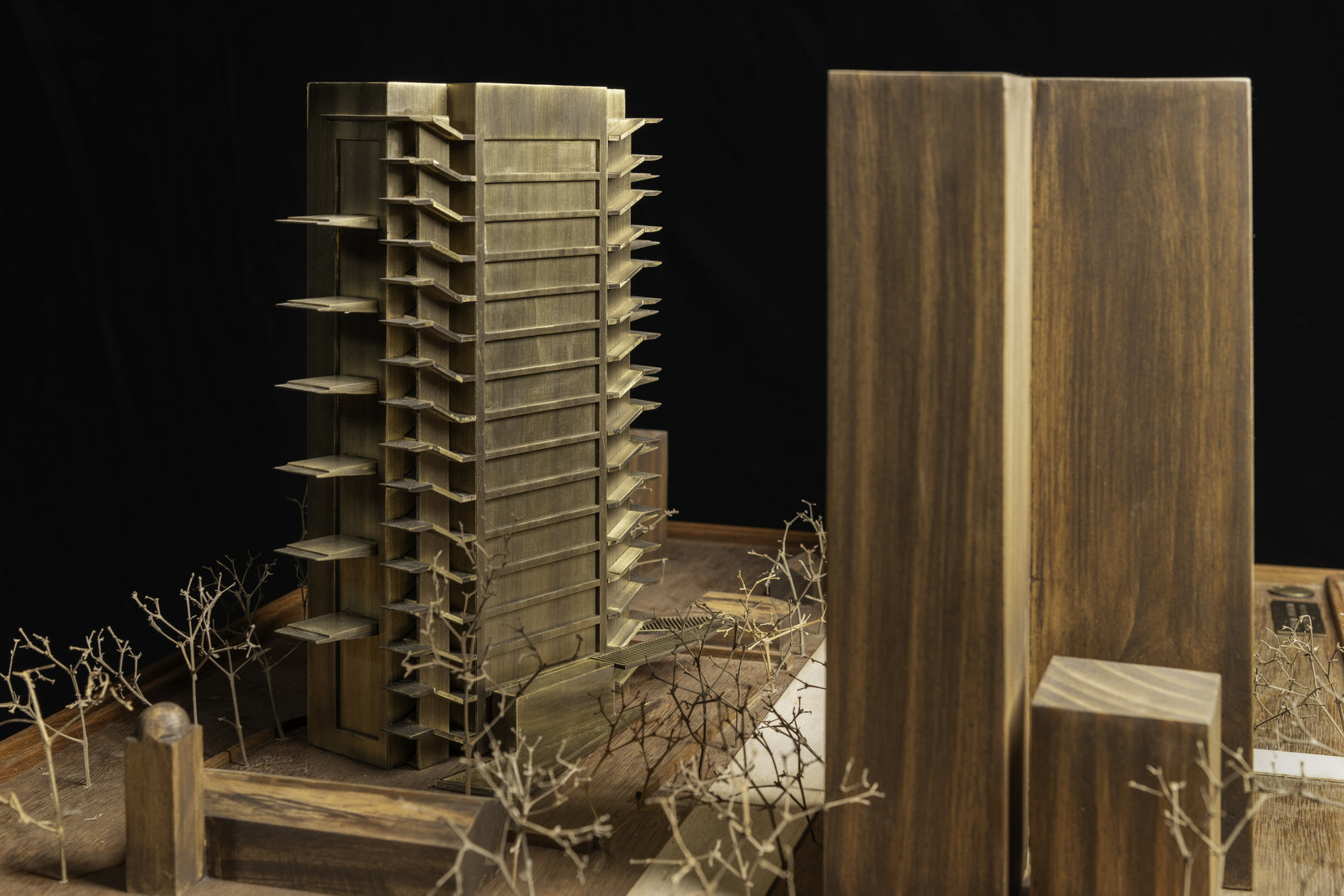 Study model of the tower in brass beside timber blocks standing for neighbouring buildings