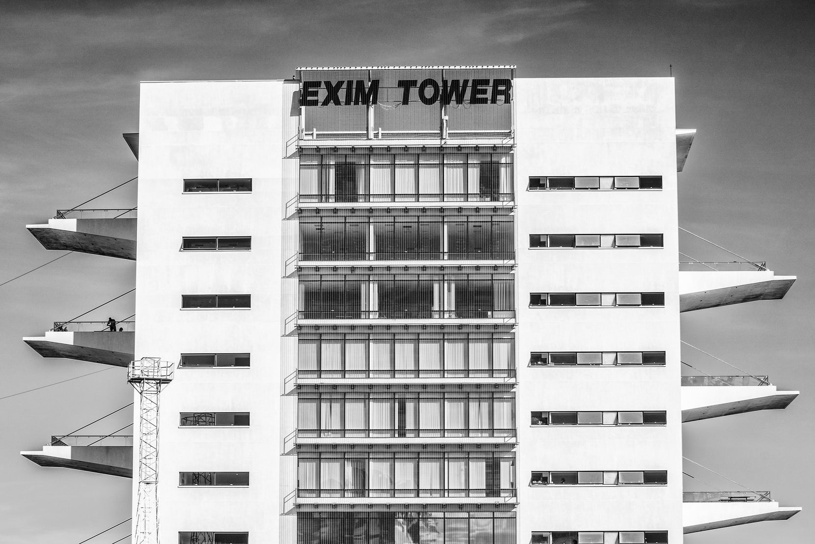Upper floors and rooftop signage, cantilevered terrace slabs projecting from either flank