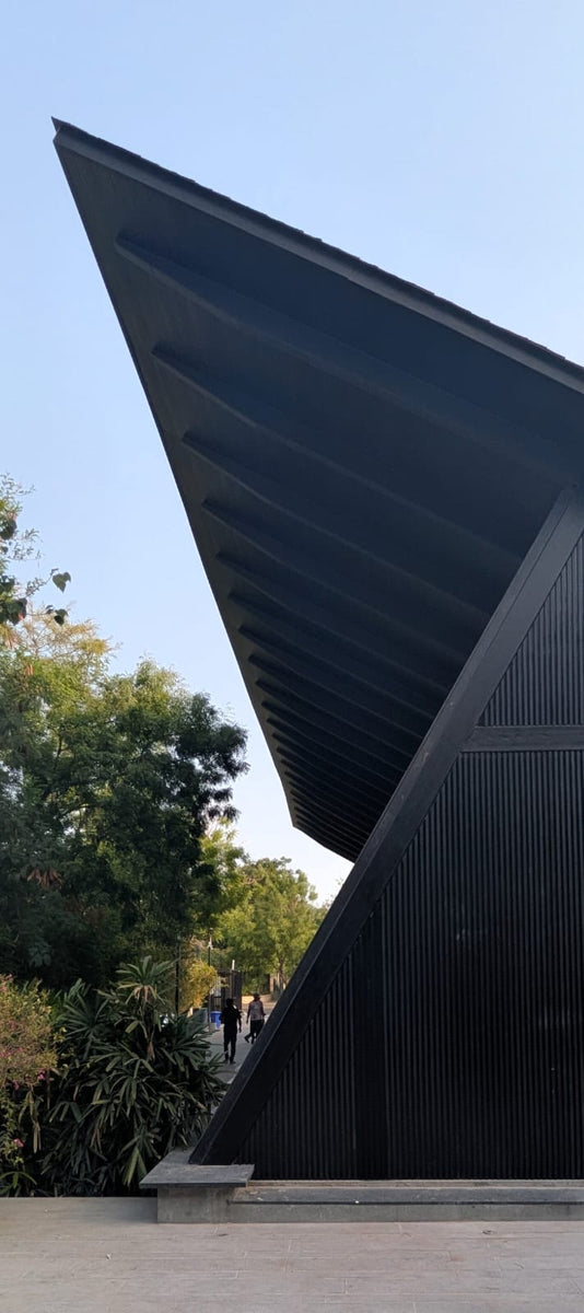 Ribbed underside of the cantilevered roof reaching out over the paved forecourt
