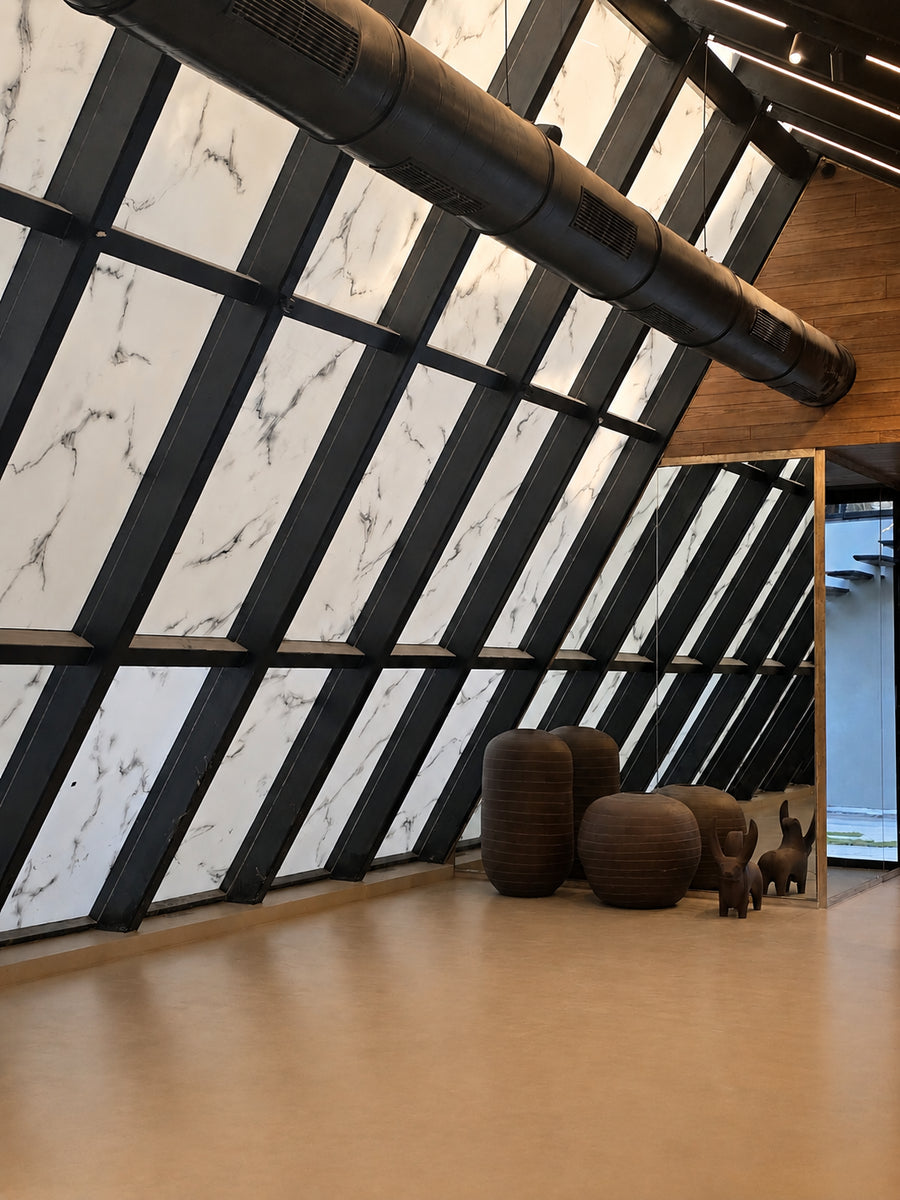 Marbled glass panels in a black grid beside ribbed ceramic pots on the resin floor
