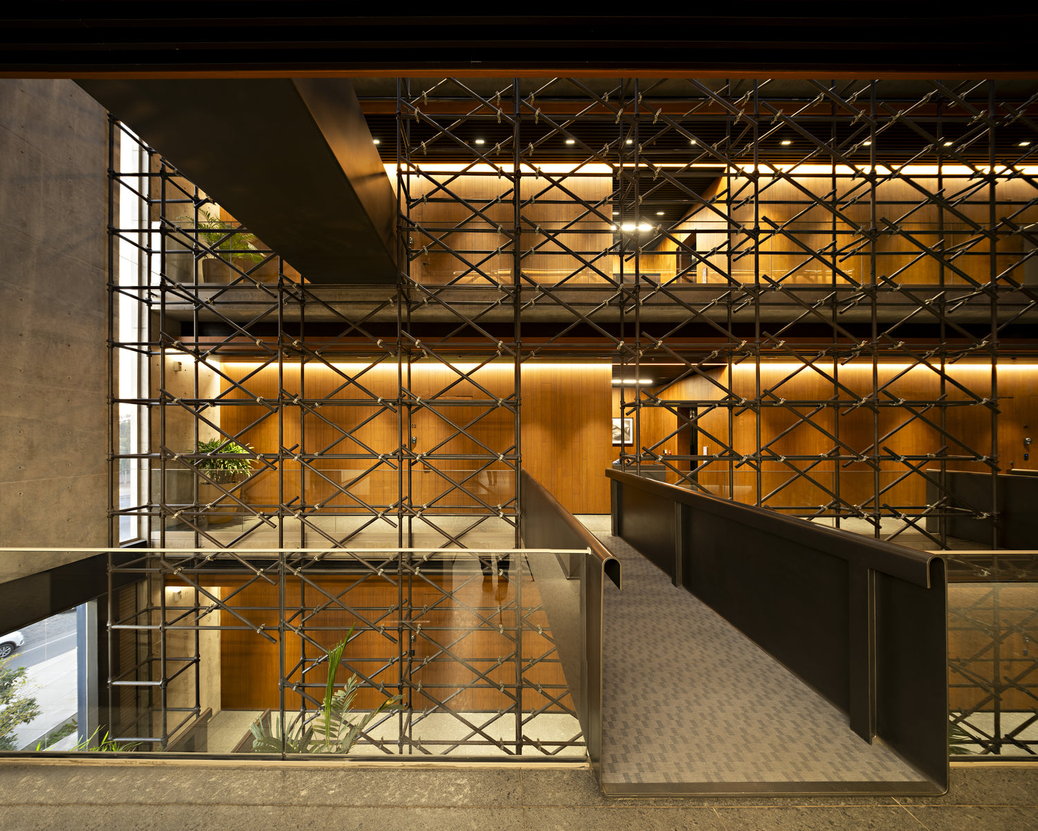 Atrium of Goyal Headquarters, a lattice of steel tubes screening timber-lined offices