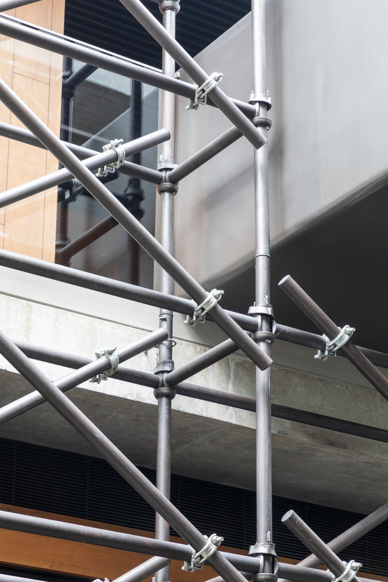 Scaffold couplers and tubes detailed against the edge of a concrete slab