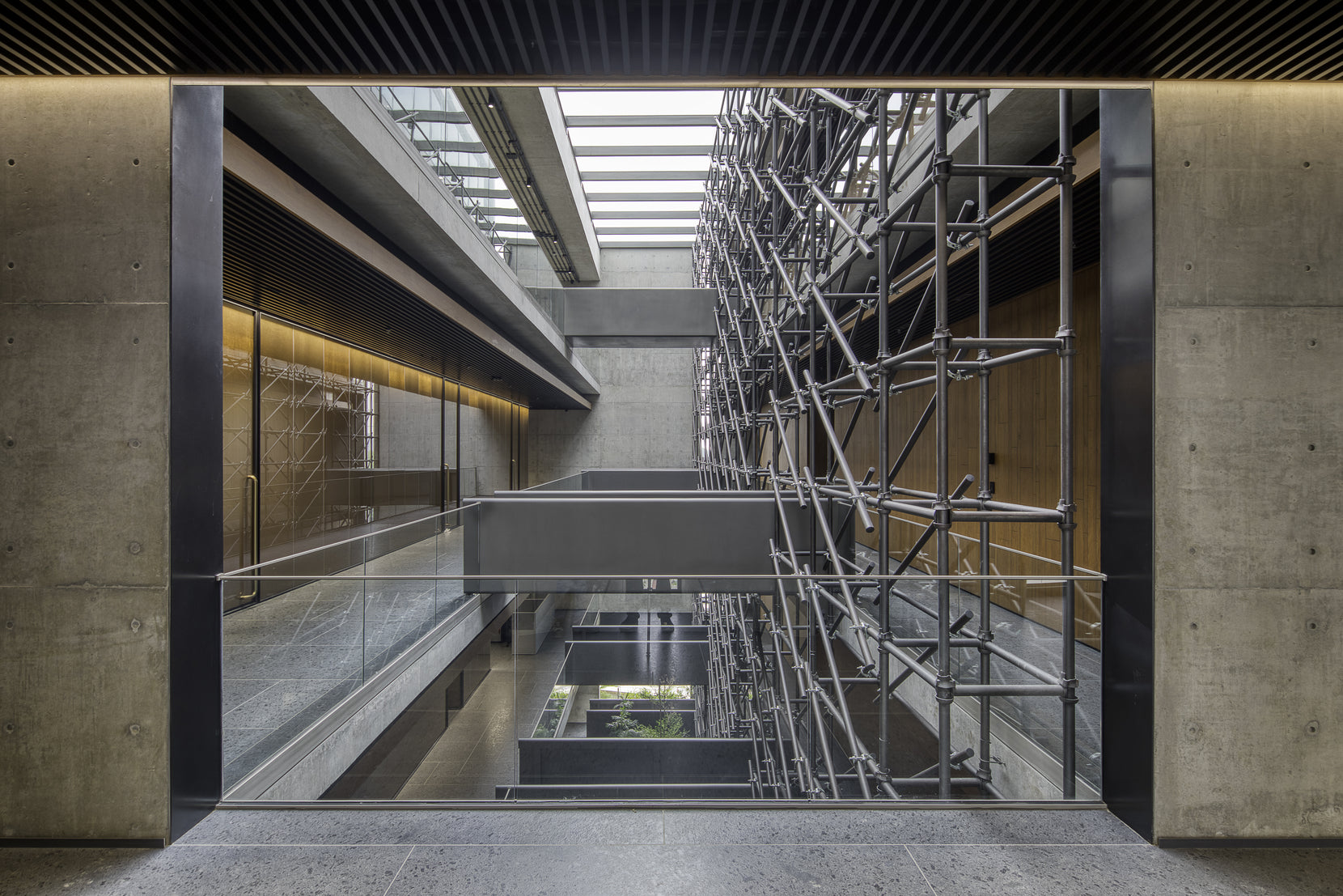 Atrium framed by a concrete portal, bridges and the tube screen beyond