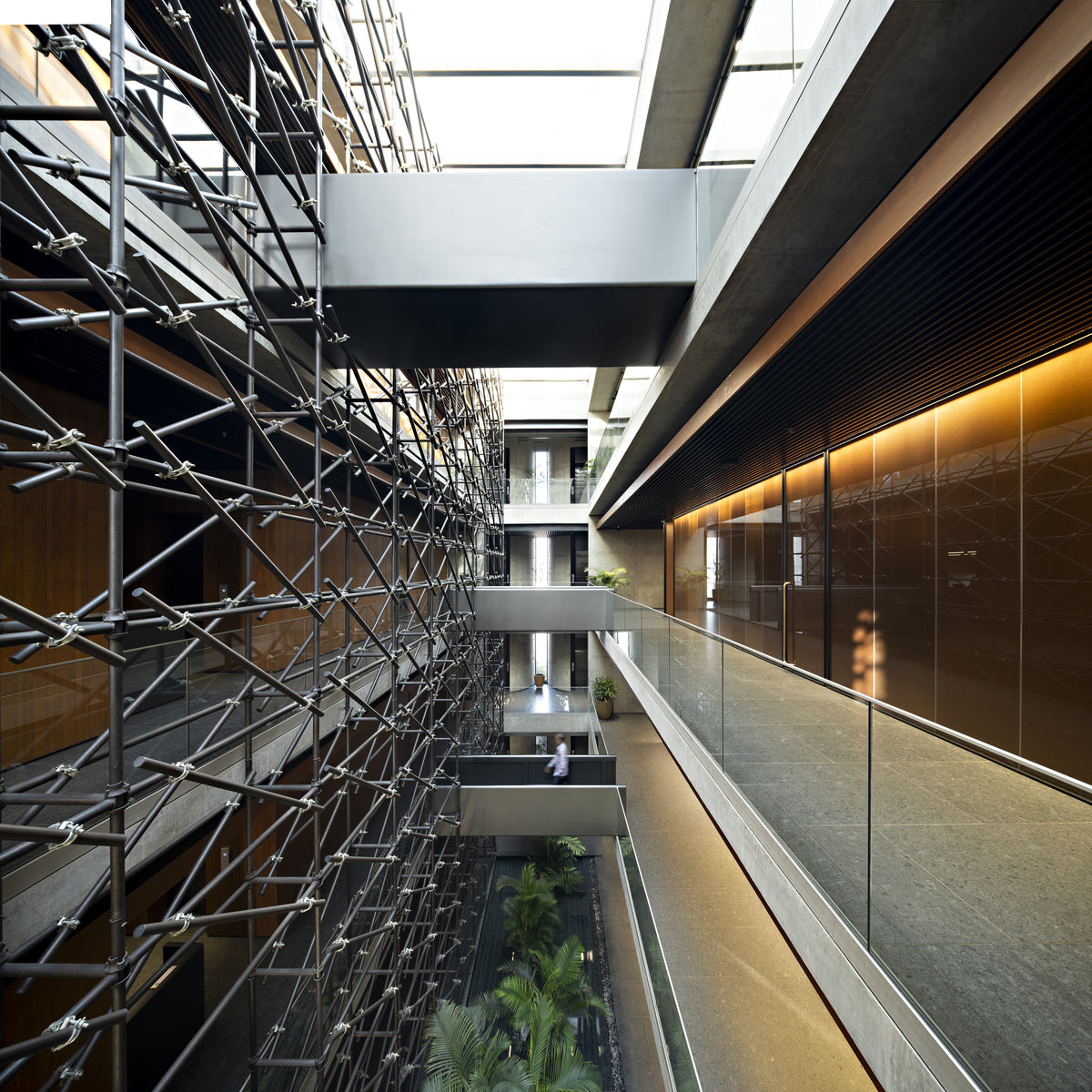 Full height of the atrium, tube screen on one side and stone-floored galleries opposite