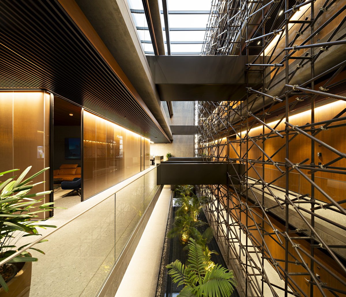 Goyal Headquarters in Ahmedabad, steel tube screen lining the top-lit atrium corridor