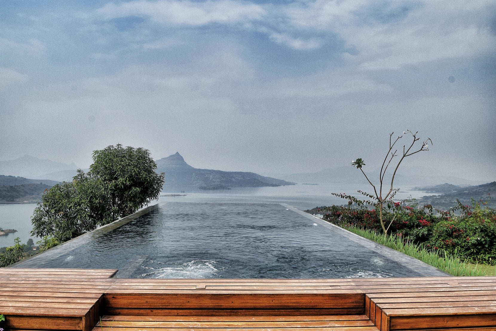 Infinity pool and timber deck facing Pawna Lake and the pinnacle on the far ridge