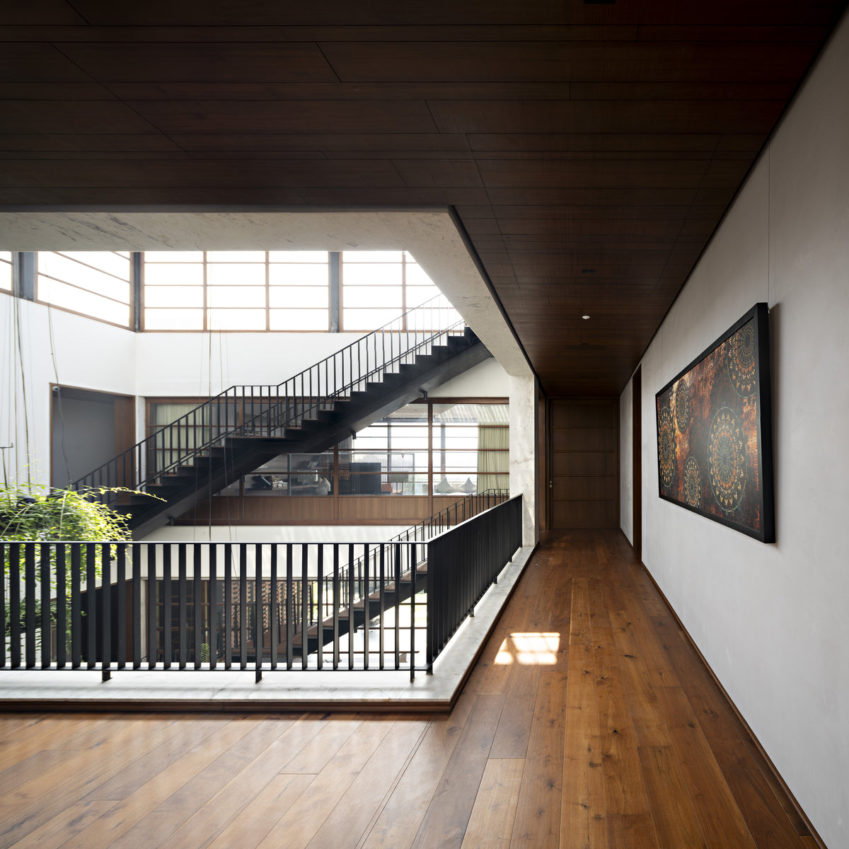 Upper gallery in oak flooring overlooking the courtyard void, artwork on the white wall