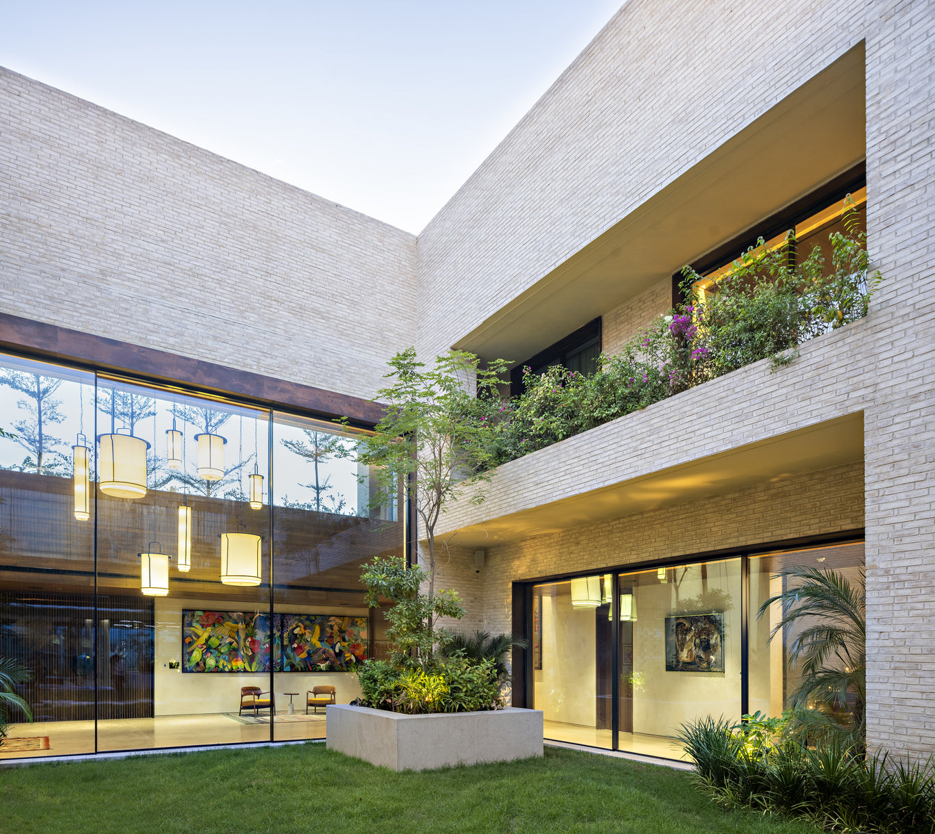 Double-height courtyard with lanterns behind glass and planting spilling from the upper terraces