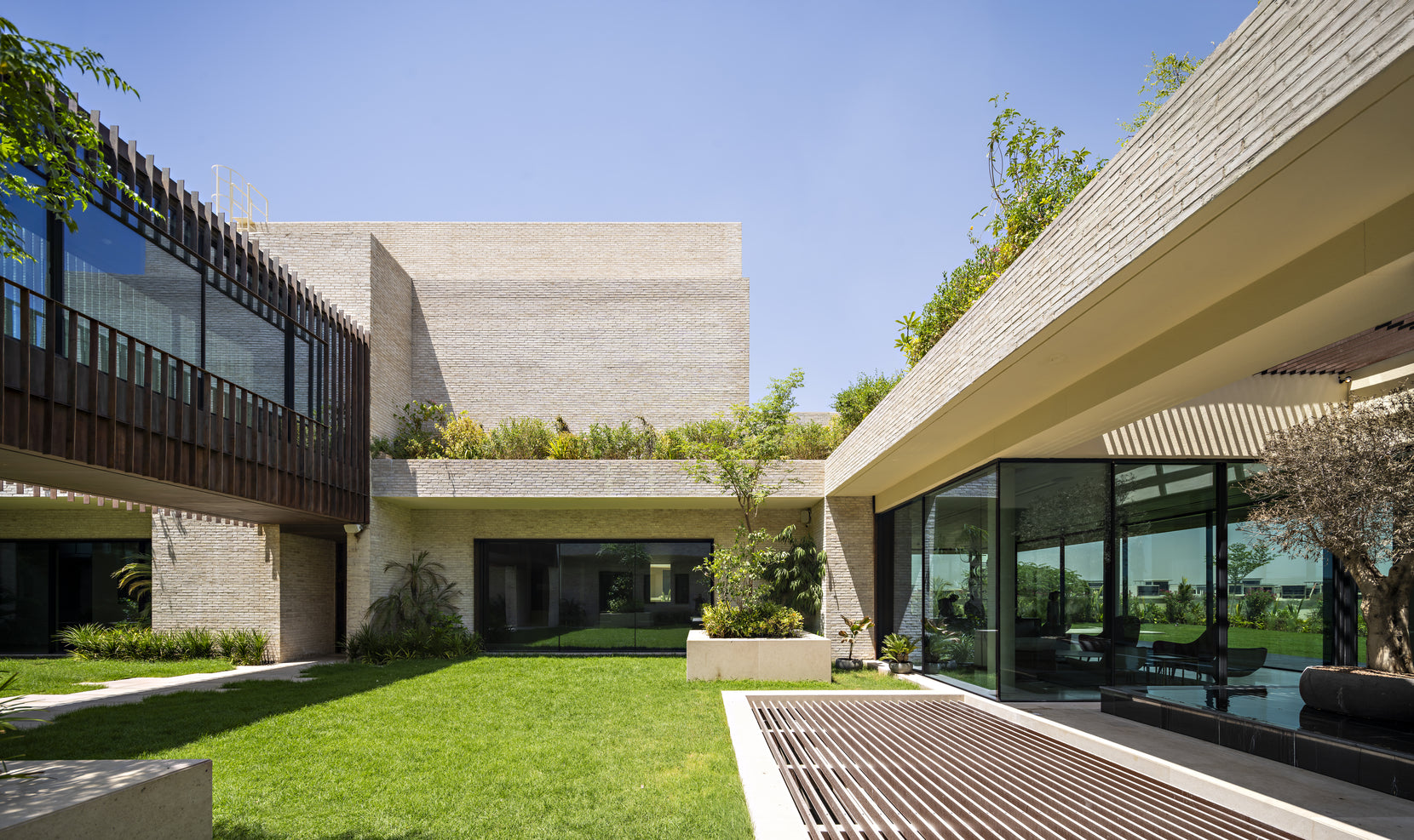 Corner of the courtyard with a timber-screened balcony and lawn running to a shaded verandah