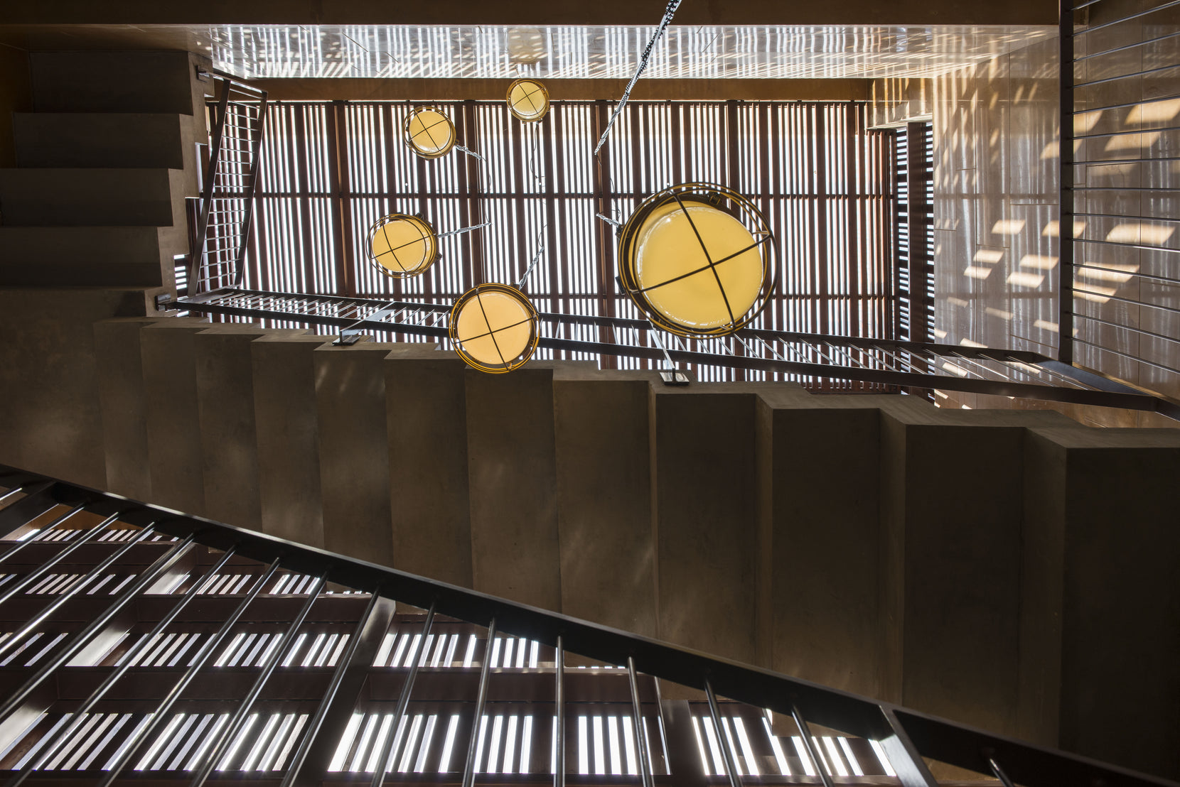 Timber grille skylight over the stairwell, round yellow lights hanging into the shaft