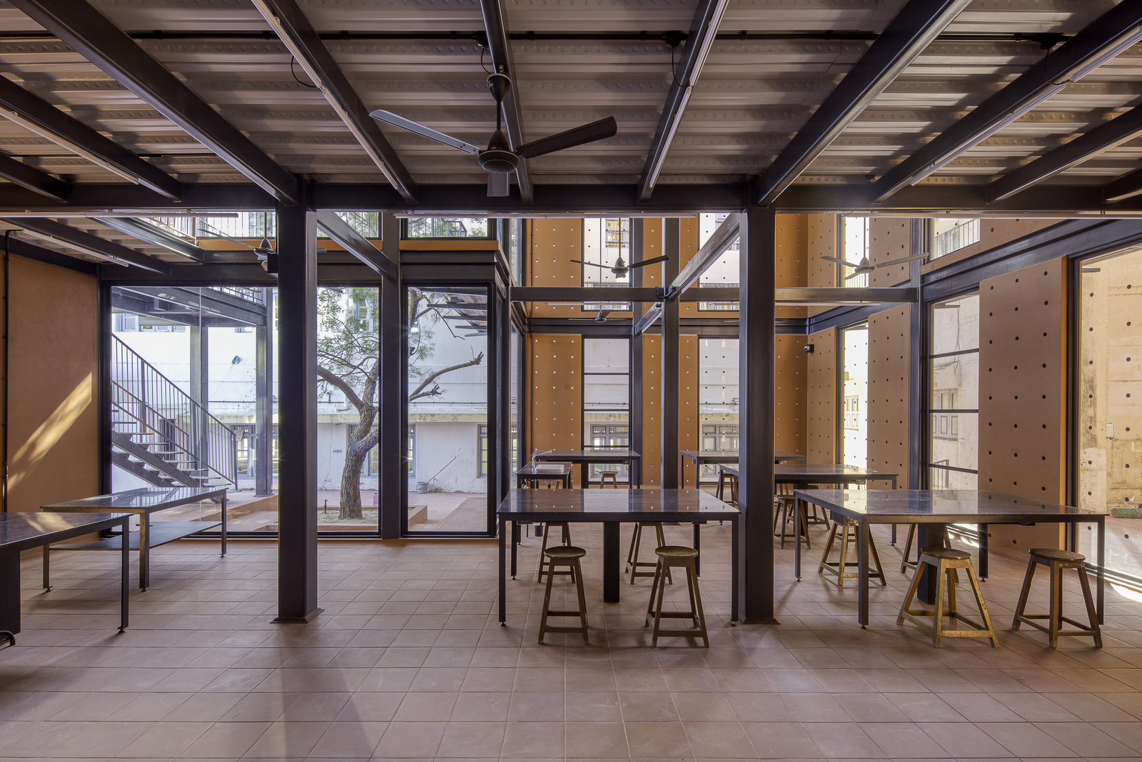 Teaching floor of tiled paving, steel columns and perforated terracotta wall panels
