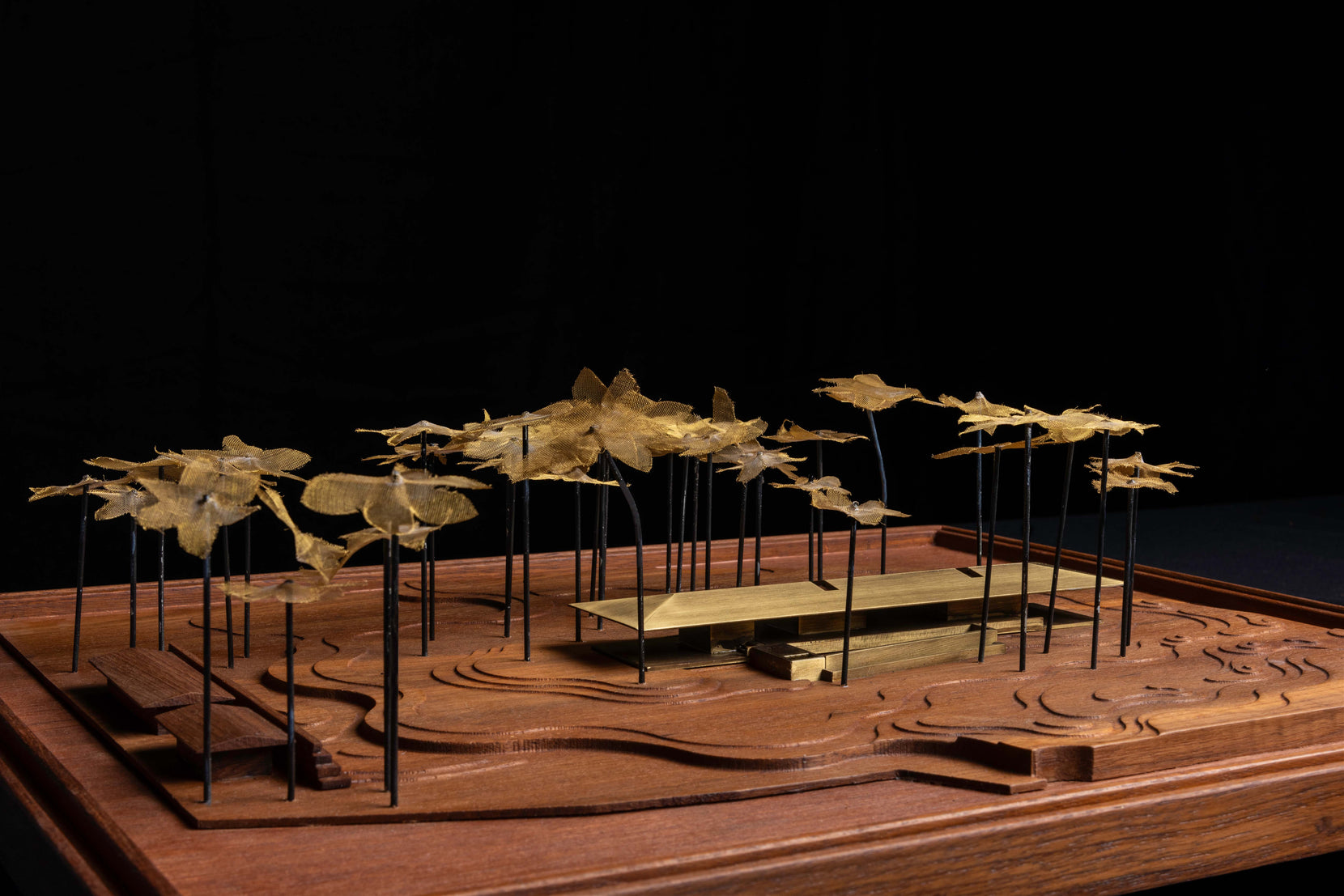 Scale model of Parikrama in timber and brass, its long bar set within a field of model palms