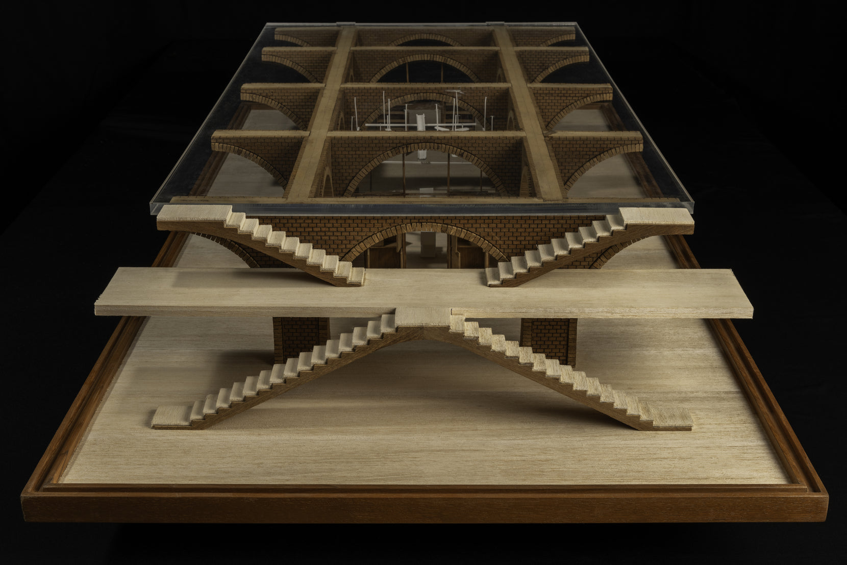 Study model end-on, crossing stair flights meeting at the base beneath a glazed roof