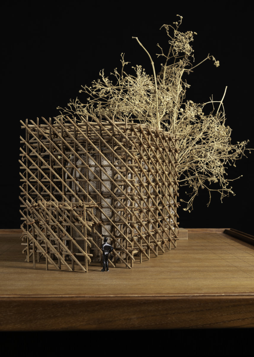 Scale model of the bamboo cage with a dried-twig tree, a scale figure at the entrance
