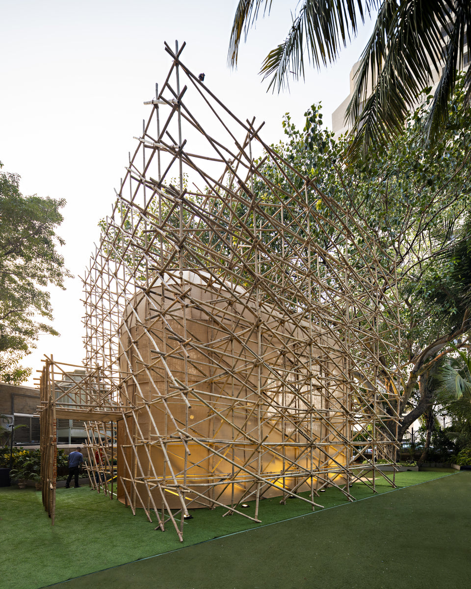 Angular bamboo cage enclosing the lit fabric chamber on the NCPA lawn